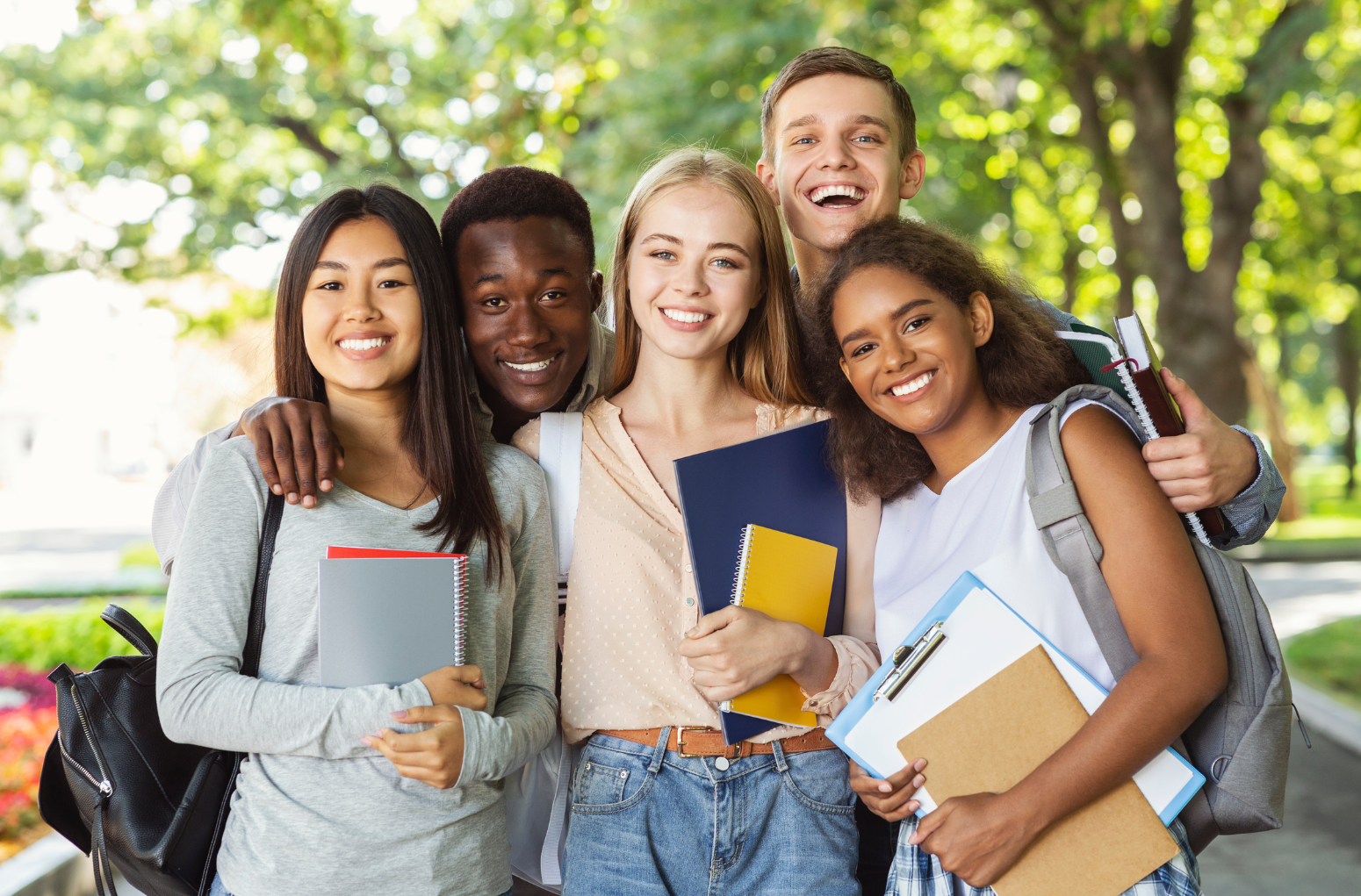 Five college students holding textbooks